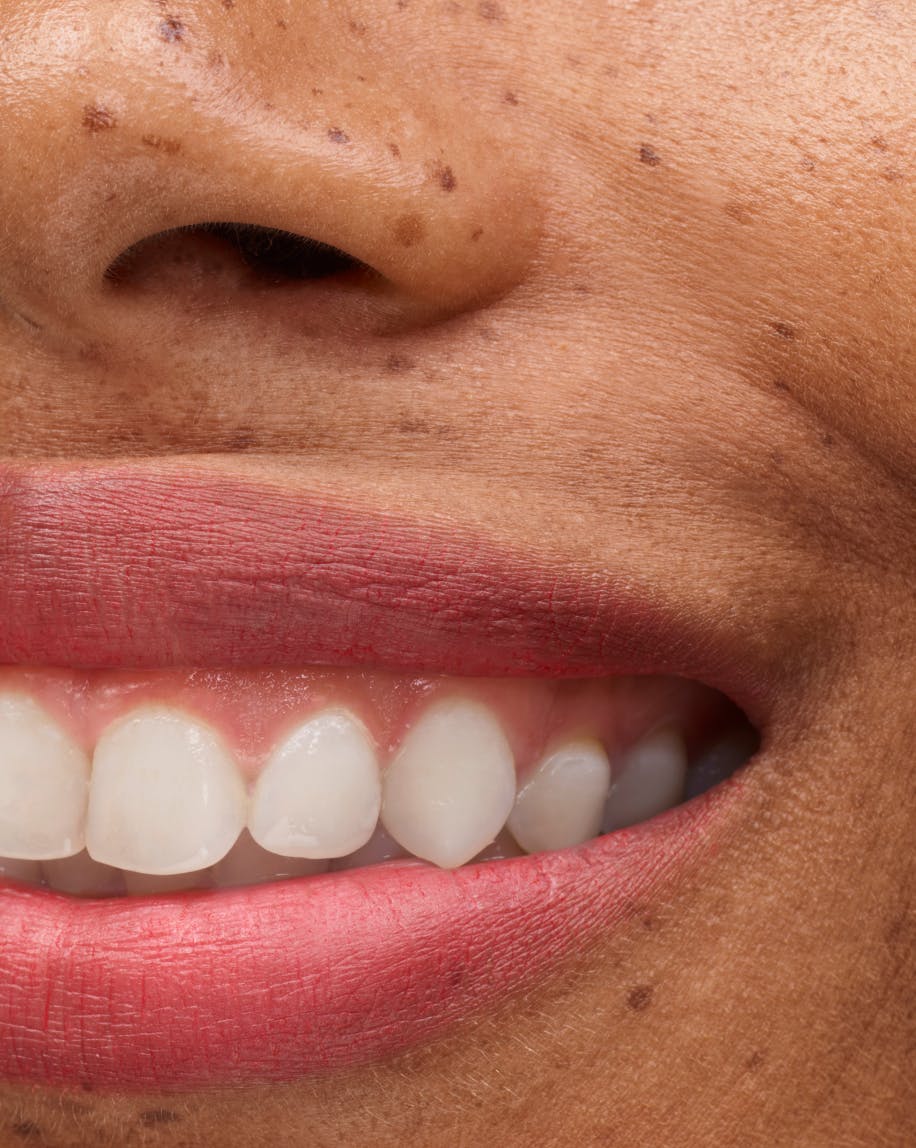 close up of smiling mouth wearing generation g in punch on lips