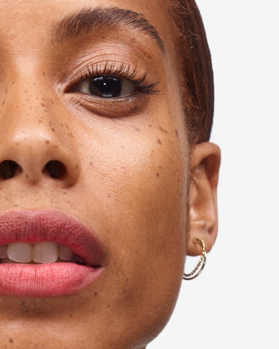close up of half of model's face wearing generation g in punch on lips
