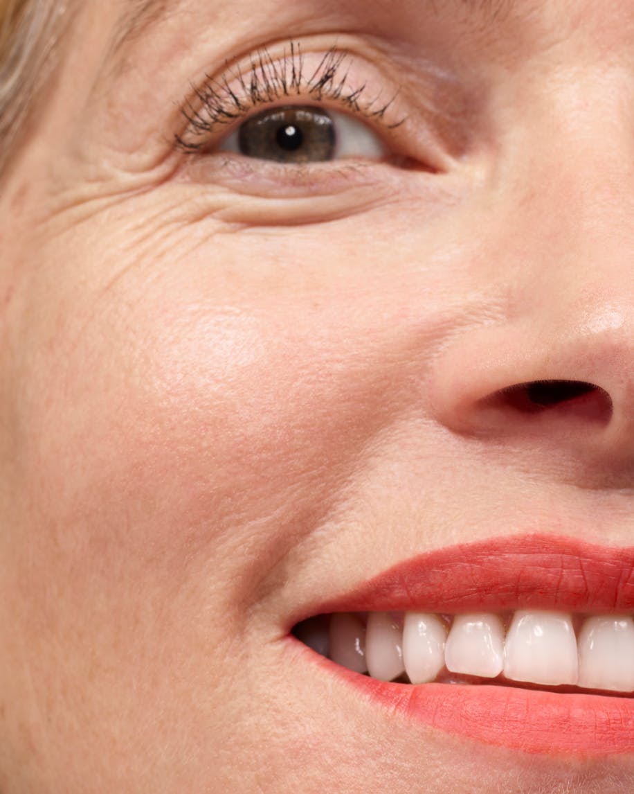 close up of half of a face smiling wearing generation g in zip on lips