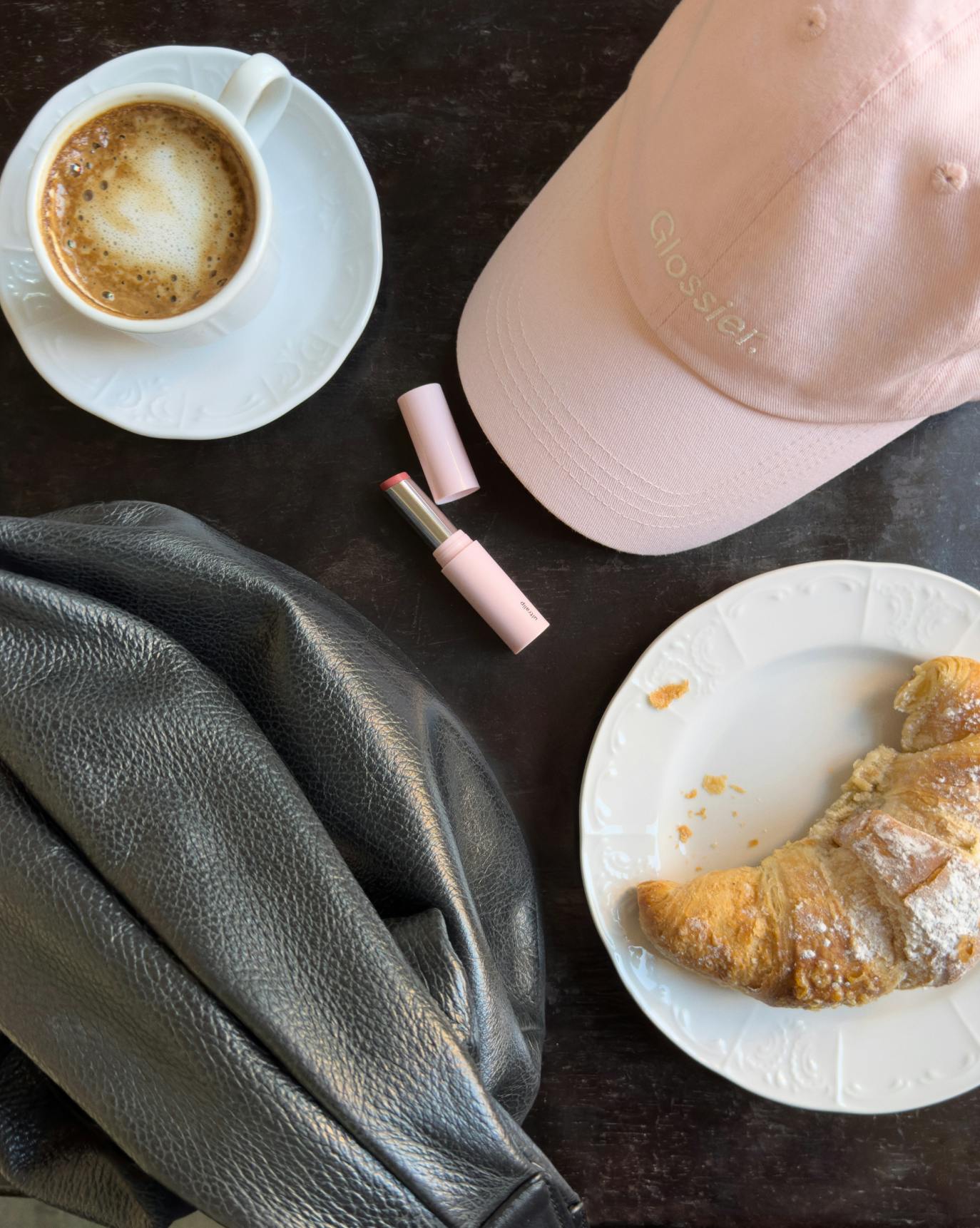 glossier pink cap on table with breakfast items