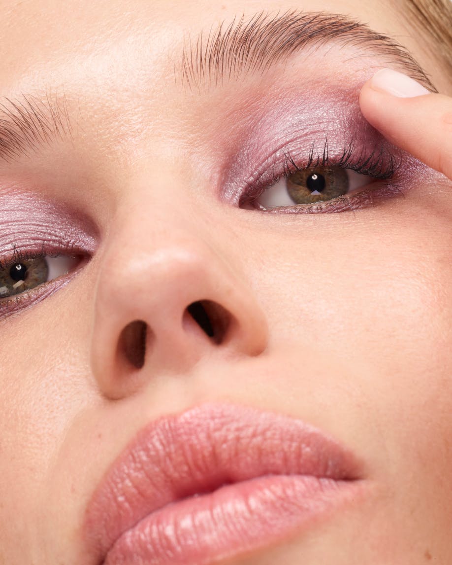 Olivia applies Monochromes in Mist to her eyelid.